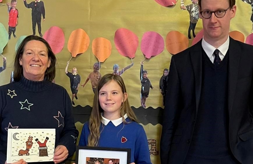 Tom Randall MP with the Killisick Junior School Headteacher holding the winning entry designed by Annabelle and Annabelle aged 10 with a framed and signed photo of the PM with her design.